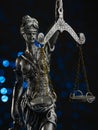 Close-up. Bronze figurine of the goddess of justice - Themis on a dark blue background with lights. Democracy, justice, court,