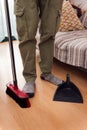 broom dustpan and feet with socks on a parquet floor