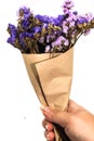 Close-up brown bouquet purple statice dry flower on hand and white background