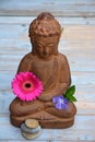 Close up of brown Buddha on used wood With zen stones and flowers