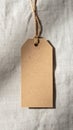 Close Up of Brown Cardboard Tag with Jute String on Textured Linen Fabric Royalty Free Stock Photo