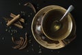 Close up of brown ceramic cup with hot green tea with gingerbread cookies, dried pears and cinnamon on dark background from above Royalty Free Stock Photo