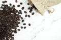 Close up brown coffee beans in a cloth bag on a marble background with copy space. Top view Royalty Free Stock Photo