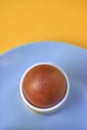 Close Up of Brown Egg in Egg Cup on Blue Plate Yellow Background Royalty Free Stock Photo