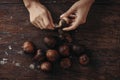 Close up brown fresh Salacca zalacca Salak snake fruit in held by a woman`s hand with natural finger nails on the wooden table