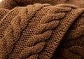 Close-up of a brown knitted garment featuring a cable knit pattern. The texture is thick and Royalty Free Stock Photo
