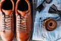 Close up of brown leather men`s boots, belt, sunglasses and blue jeans top view Royalty Free Stock Photo