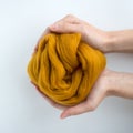 Close-up of brown merino wool ball in hands Royalty Free Stock Photo