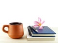 coffee cup and two diary books with pen and pink plumeria (frangipani) flower on wooden table isolated on white copy Royalty Free Stock Photo