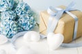 Close up of brown recycle gift box with white heart and blue Hydrangea flowers on blue wooden background Royalty Free Stock Photo