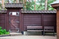 Close-up on a wooden door with forged iron hinged patterns and two old benches Royalty Free Stock Photo