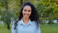 Close-up brunette female lady with luxurious long curly black dark healthy hair walks in park in nature outdoors looking Royalty Free Stock Photo