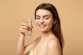Close up brunette half naked woman 20s with perfect skin nude make up glass water isolated on beige pastel wall Royalty Free Stock Photo