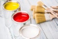 Close-up brushes lying on multicolored paint cans