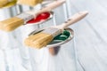 Close-up brushes lying on multicolored paint cans