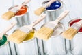 Close-up brushes lying on multicolored paint cans