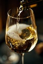 Close-up of a bubbling glass of white wine being filled, capturing the effervescence and golden hue of the drink against Royalty Free Stock Photo