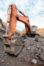 Close up of the scoop of an excavator digging ore rocks
