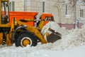 close-up bucket of a yellow tractor to clean dirty snow on the city streets after heavy snowfalls