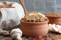 Close up buckwheat porridge in the pot with butter, mushrooms and dried tomatoes