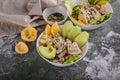 Close up Buddha bowl with chicken meat, bulgur, white beans, quinoa, avocado, lemon and fresh cucumber