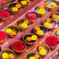 Close-up on Buddhist flower offerings in bowls.