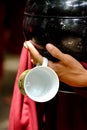 Close up of buddhist monk hands holding a vintage bowl and cup Royalty Free Stock Photo