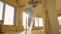 CLOSE UP: Builder climbs down from stepladder placed inside prefabricated house Royalty Free Stock Photo