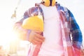 Close up of builder holding hardhat on building