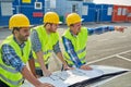 Close up of builders with blueprint on car hood