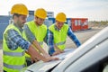 Close up of builders with blueprint on car hood Royalty Free Stock Photo