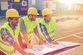 Close up of builders with blueprint on car hood Royalty Free Stock Photo