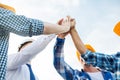 Close up of builders in hardhats making high five