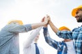 Close up of builders in hardhats making high five