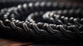 A close up of a bunch of black rope on top of wood, AI