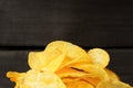 Close-up of a bunch of potato chips on a dark wood Royalty Free Stock Photo