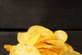 Close-up of a bunch of potato chips on a dark wood