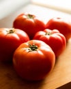 closeup of a bunch of red tomatoes on a wooden board at kitchen table Royalty Free Stock Photo