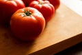 closeup of a bunch of red tomatoes on a wooden board at kitchen table Royalty Free Stock Photo