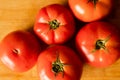 closeup of a bunch of red tomatoes on a wooden board at kitchen table Royalty Free Stock Photo