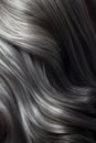 Close-up of a bunch of shiny straight gray hair in a wavy curved style.