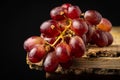 Close-up of bunch of wet black grapes on rustic wooden table, black background, horizontal, Royalty Free Stock Photo