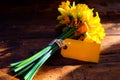 close up of a bunch of yellow daffodils tied together with string and a yellow blank tag