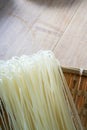 Close-up of a bundle of dried rice noodles on a bamboo dustpan, raw snail noodles