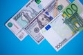 close up bundle of money Euros, dollars, rubles banknotes on the blue background, business, finance, saving, banking concept