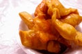 Close up of bunuelos served on a white plastic plate doused in honey Royalty Free Stock Photo