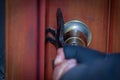 Close up of a burglar with crowbar trying break the door to enter the house