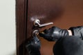 Close up of a burglar with gloves picking a lock. Thief with a passkey. Royalty Free Stock Photo