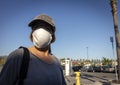 Close up of burnette woman wearing face mask with baseball cap in store parking lot