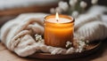 Close up of Burning candle in small amber glass jar on wooden plate - Cozy lifestyle concept